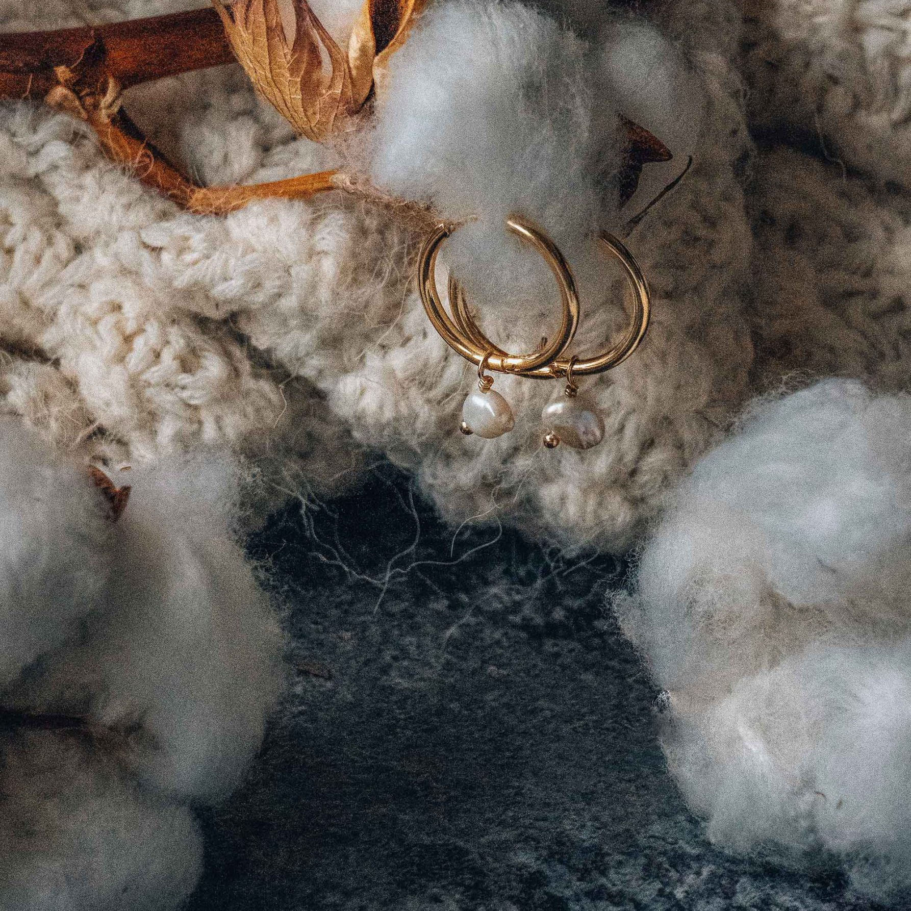 Créoles avec pendants en nacre suspendues sur branche de coton